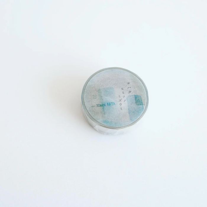 YOHAKU washi tape titled 'Secret Water' (Y-125), featuring a collage of muted blues, greens, and beige with vintage-style typed letters and numbers, ideal for adding a subtle, artistic layer to crafts, journals, and scrapbooks.