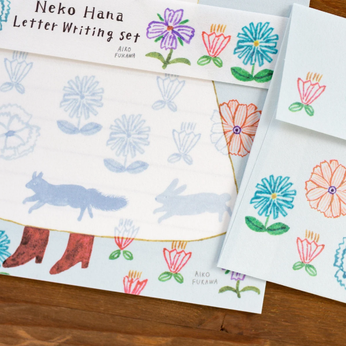 Aiko Fukawa letterhead featuring a cute cat and colorful floral design in a one-piece outfit, Japanese stationery with whimsical illustration style.