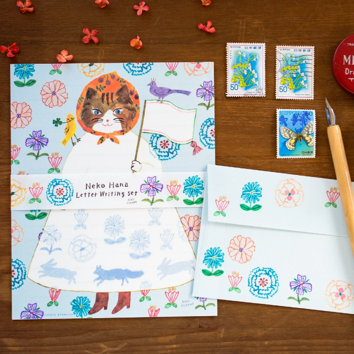 Aiko Fukawa letterhead featuring a cute cat and colorful floral design in a one-piece outfit, Japanese stationery with whimsical illustration style.