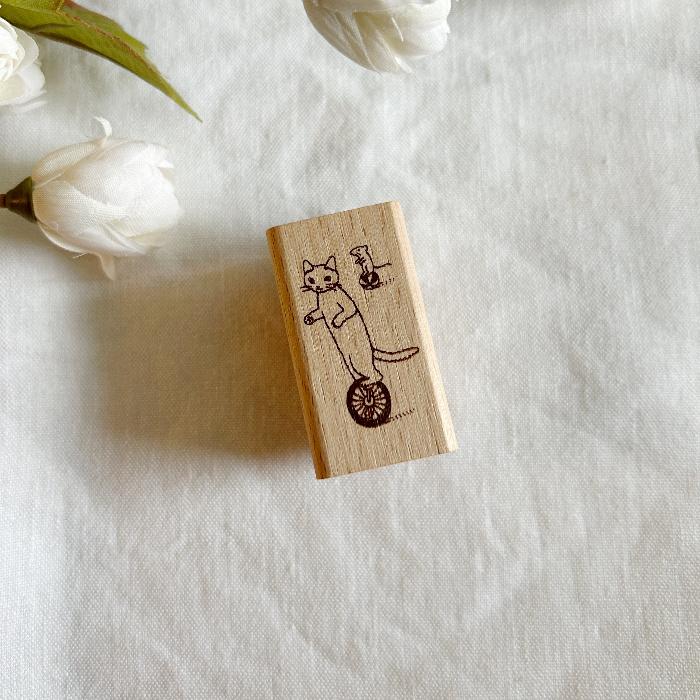 Pottering Cat rubber stamp titled 'Unicycle,' featuring a playful cat riding a unicycle, Japanese stationery perfect for adding a playful and adventurous touch to planners, journals, and crafts.