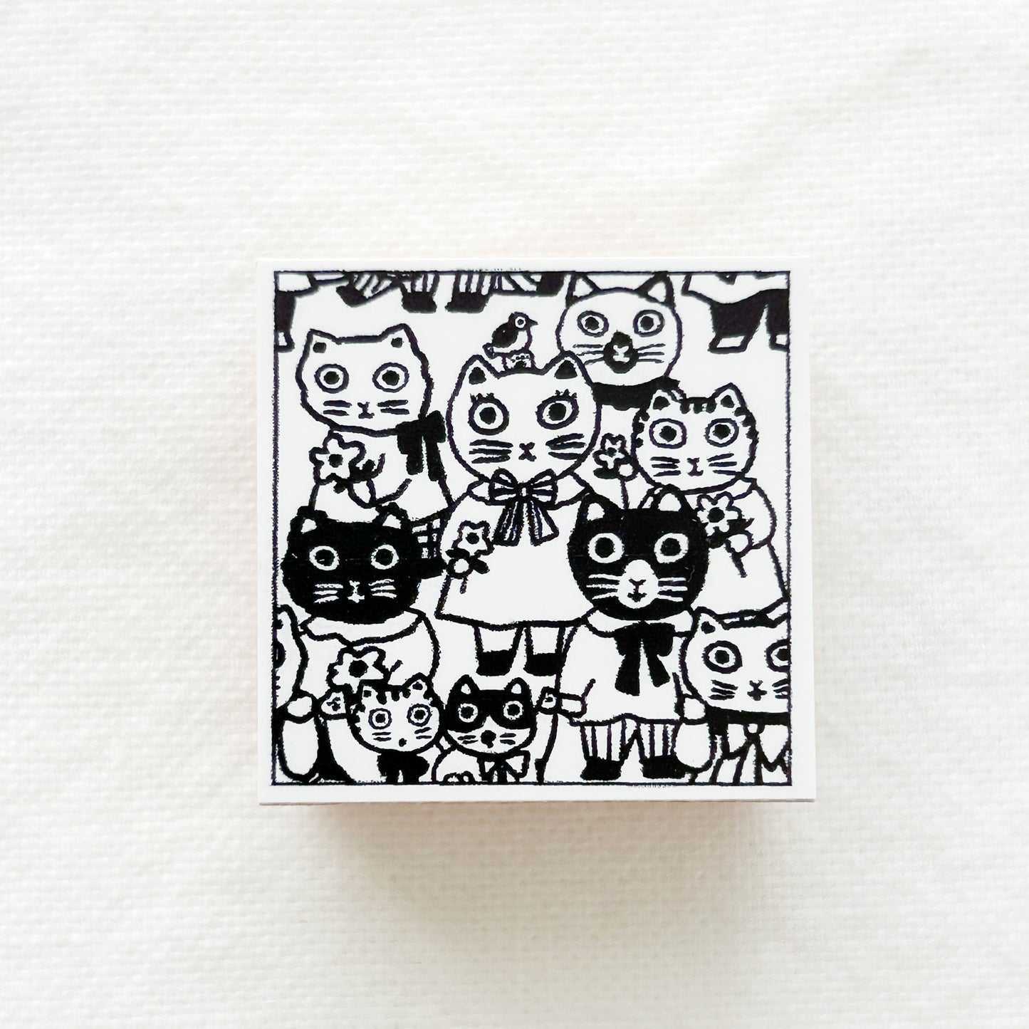 A square wooden rubber stamp of lots of cats