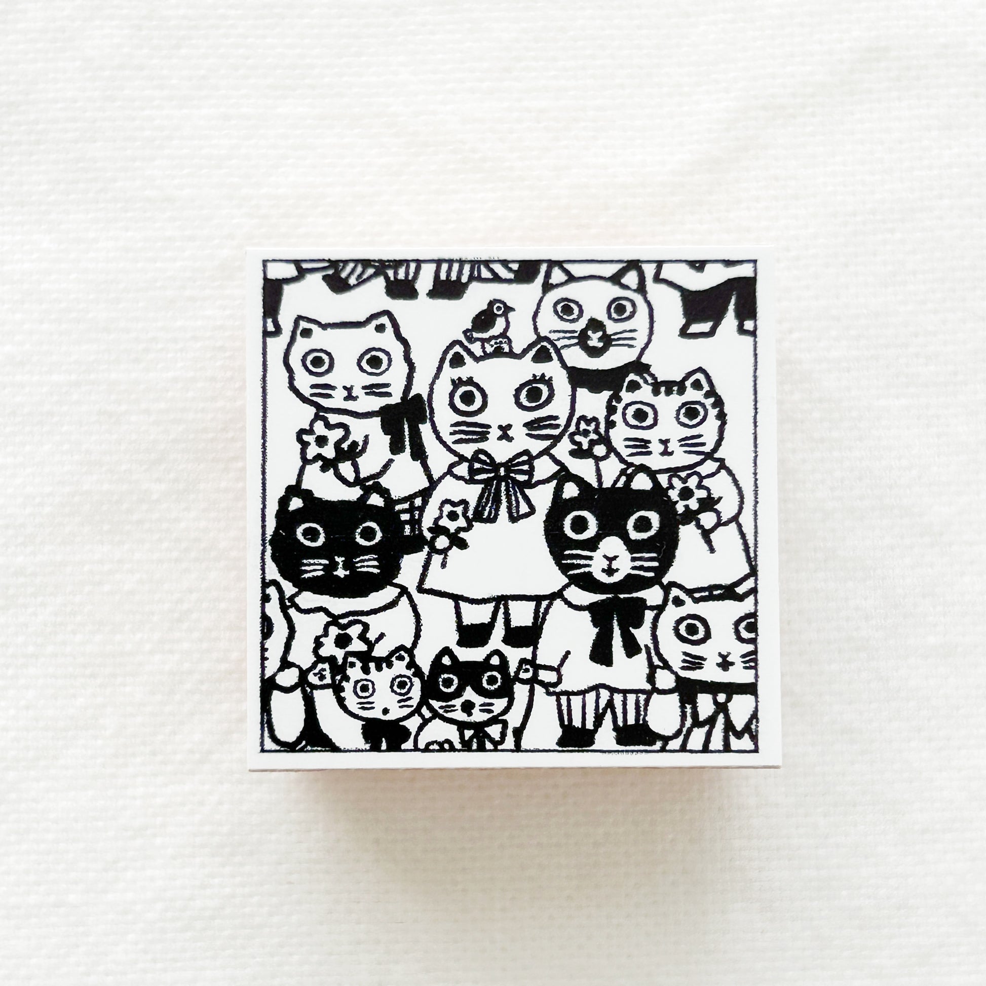 A square wooden rubber stamp of lots of cats