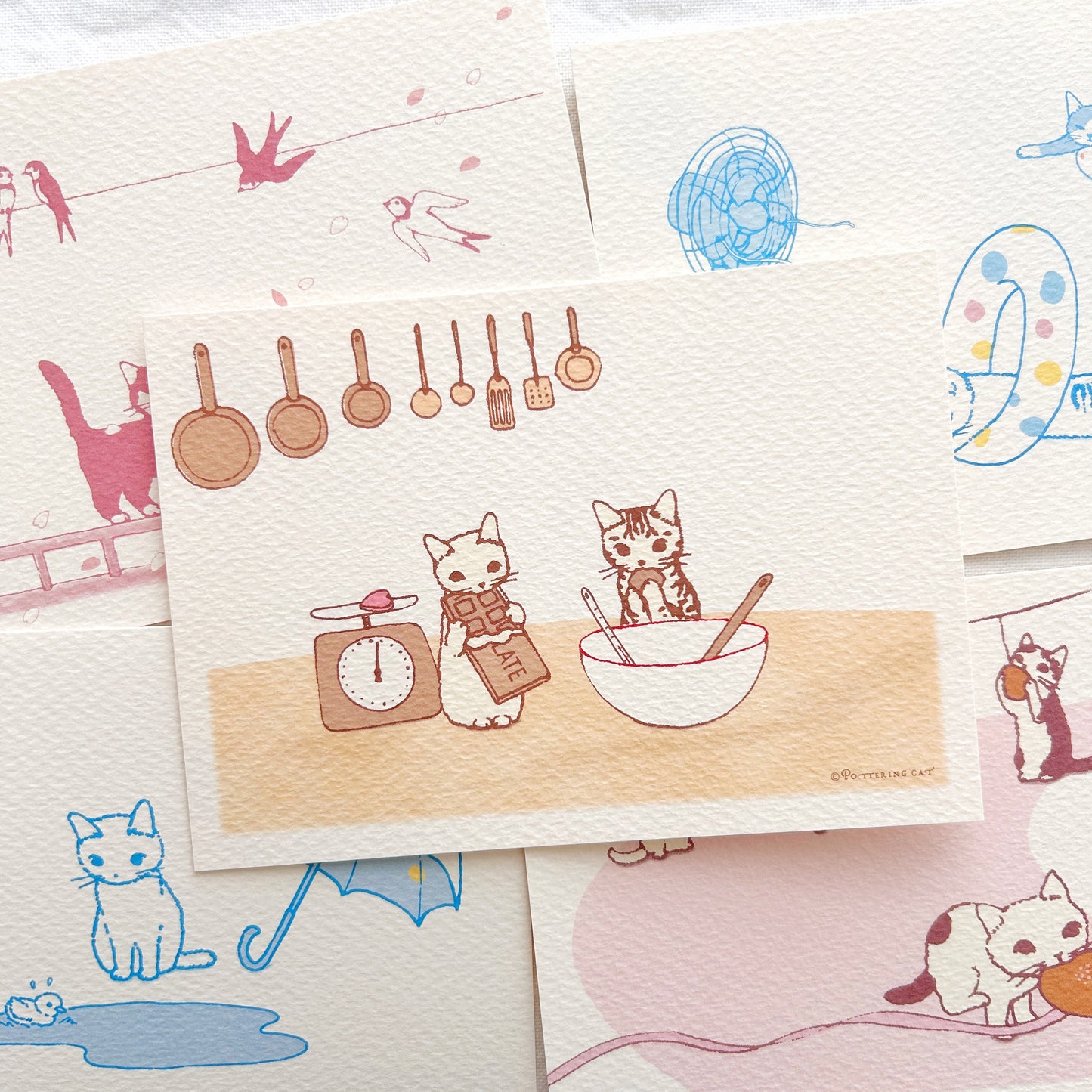 A collection of postcards with cute cat illustrations