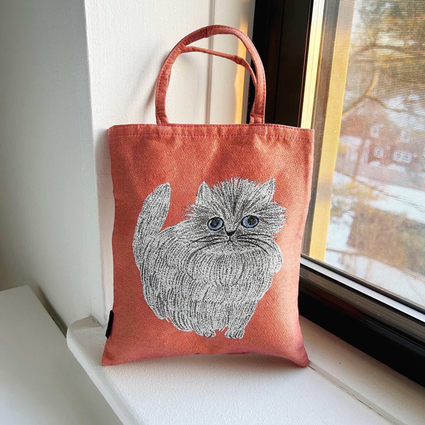 A tote bag with a cat design