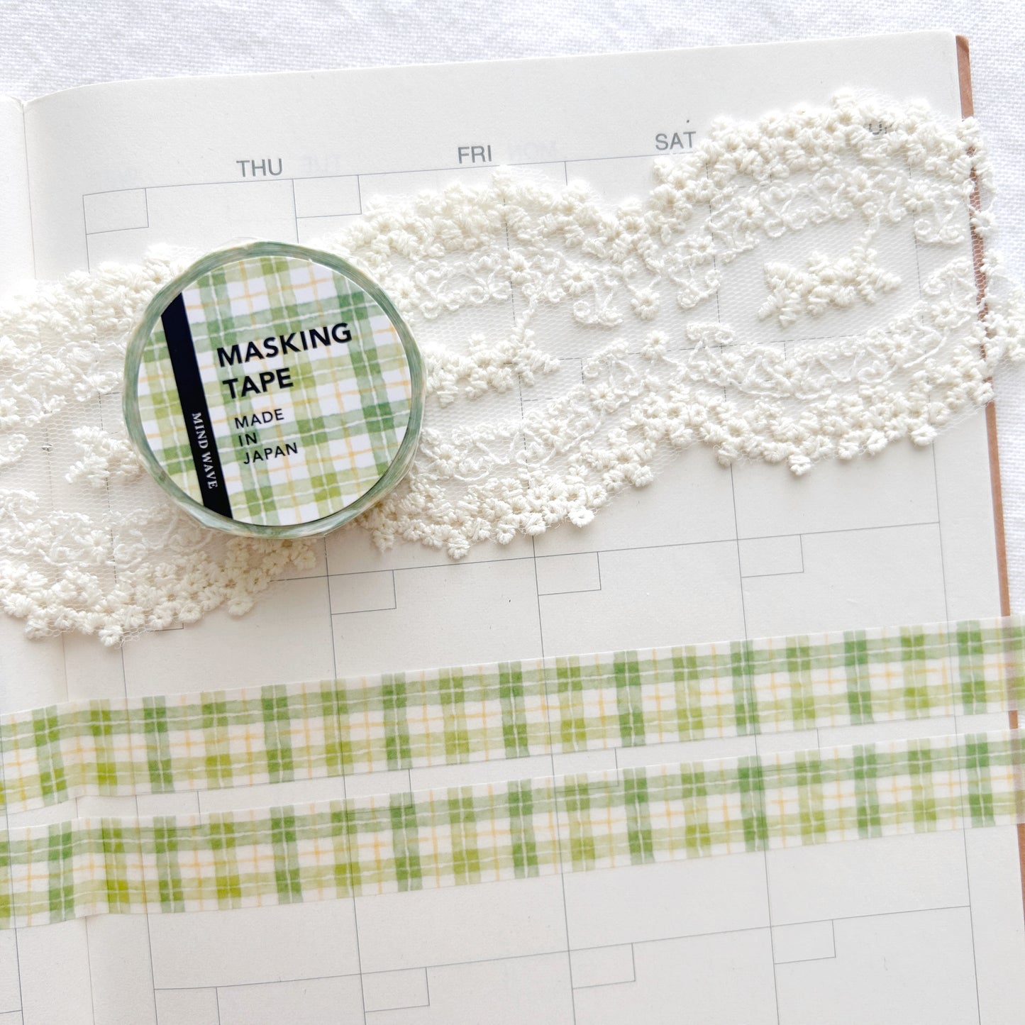 Washi tape with a green and white checkered pattern on a planner page.
