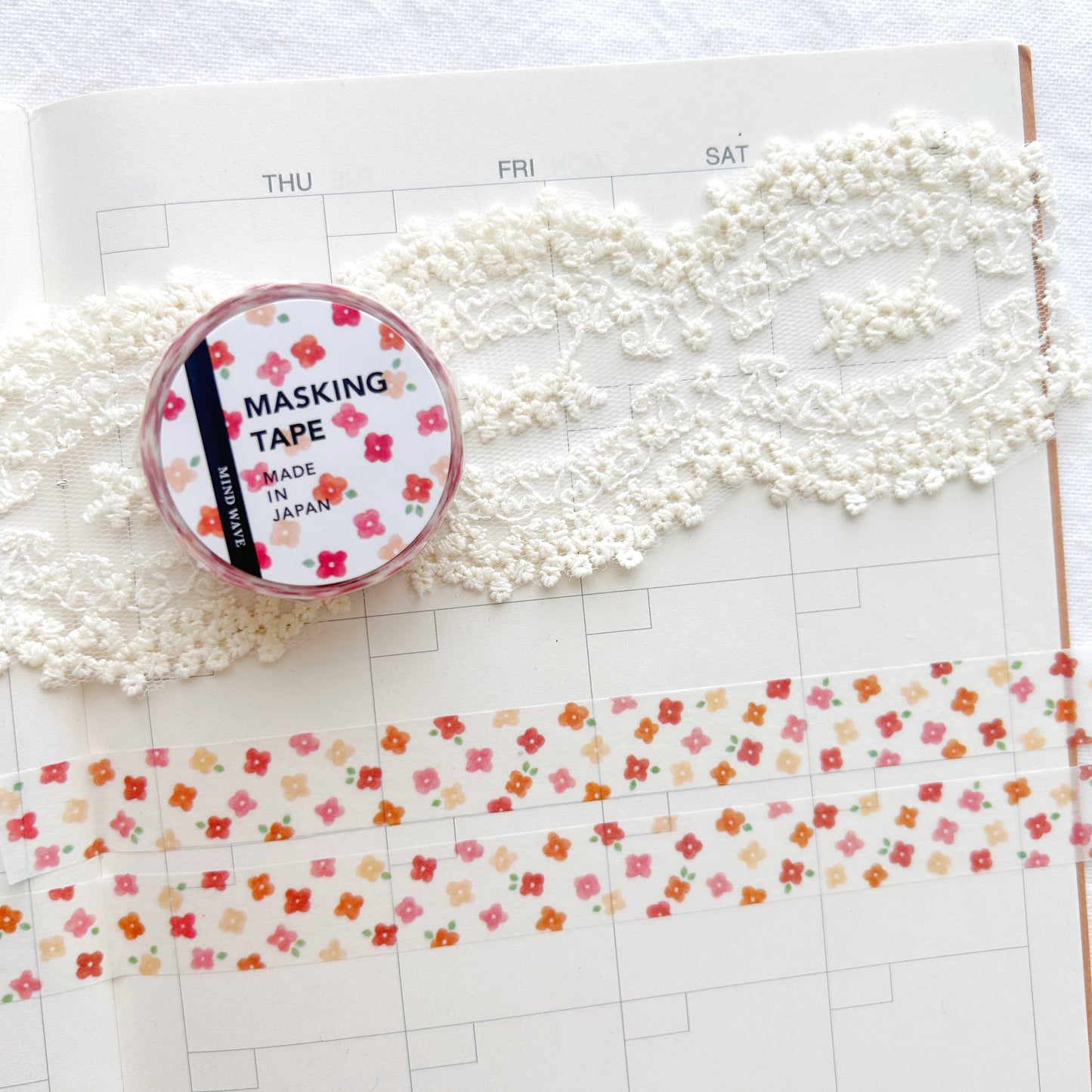 Washi tape with a whimsical red floral design on a planner