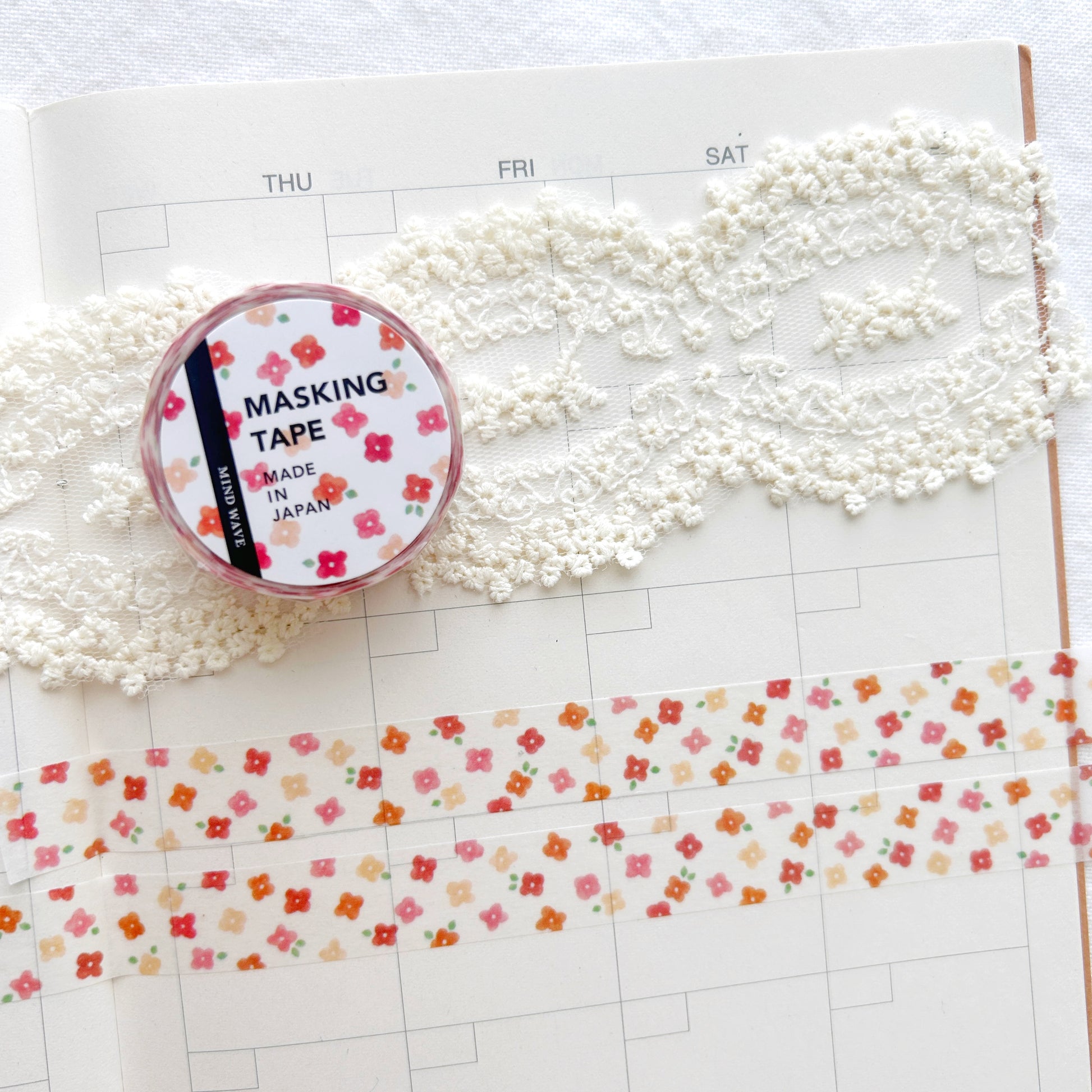 Washi tape with a whimsical red floral design on a planner