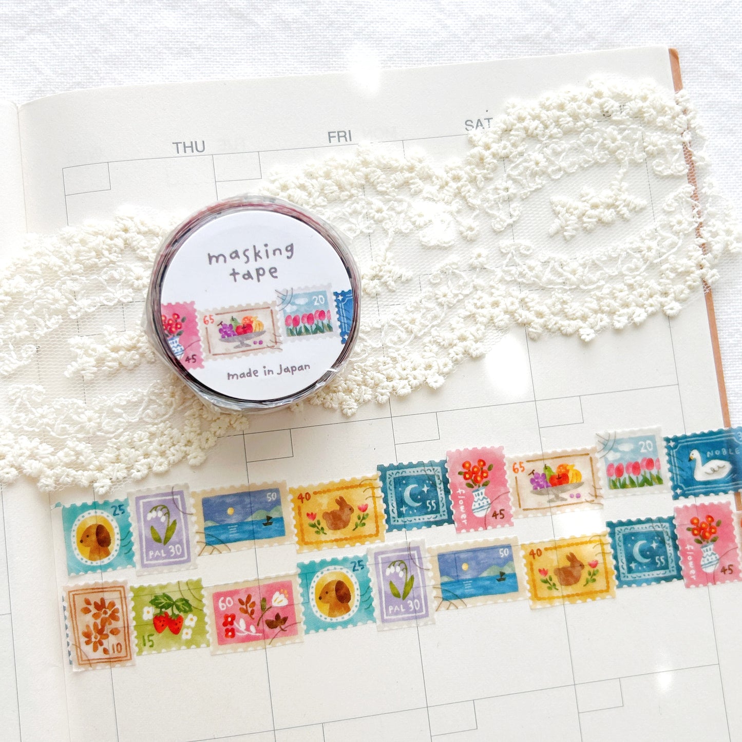 Whimsical washi tape with a stamp style design including dogs, bunnies, flowers on a planner