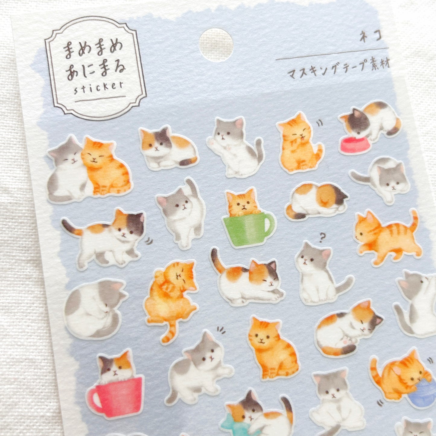 Sheet of cat-themed stickers on a light blue background