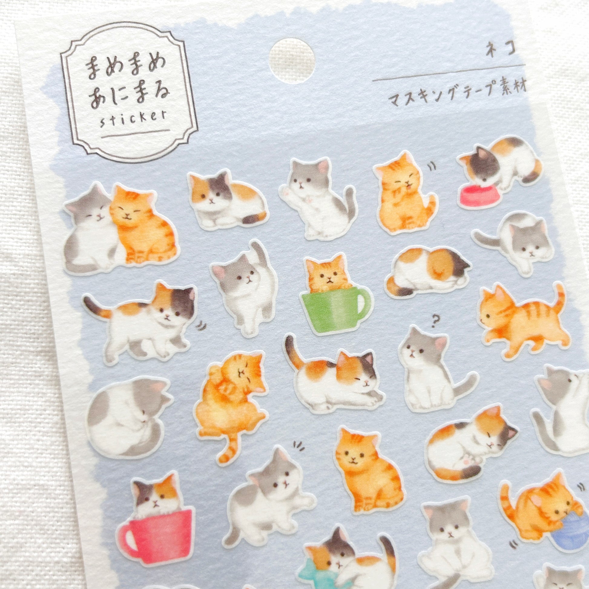 Sheet of cat-themed stickers on a light blue background