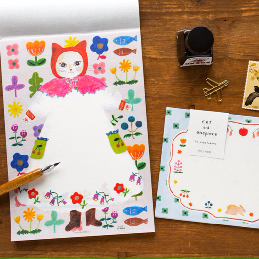 Aiko Fukawa letterhead featuring a cute cat and colorful floral design in a one-piece outfit, Japanese stationery with whimsical illustration style