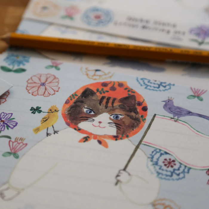 Aiko Fukawa letterhead featuring a cute cat and colorful floral design in a one-piece outfit, Japanese stationery with whimsical illustration style.