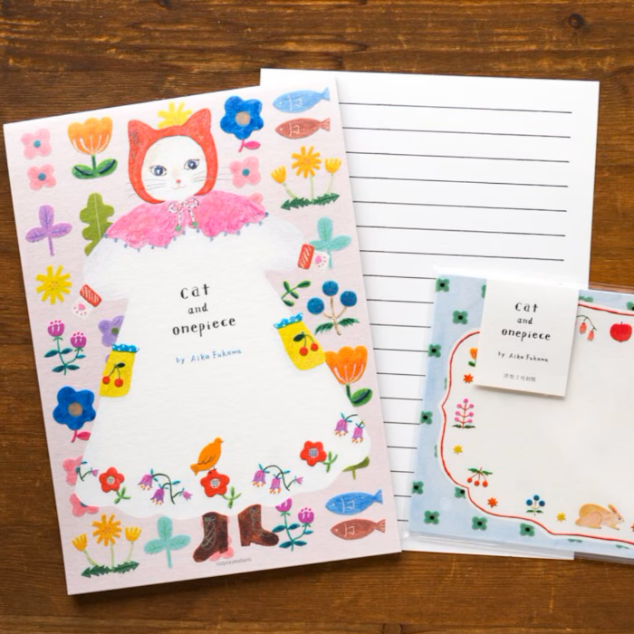 Aiko Fukawa letterhead featuring a cute cat and colorful floral design in a one-piece outfit, Japanese stationery with whimsical illustration style