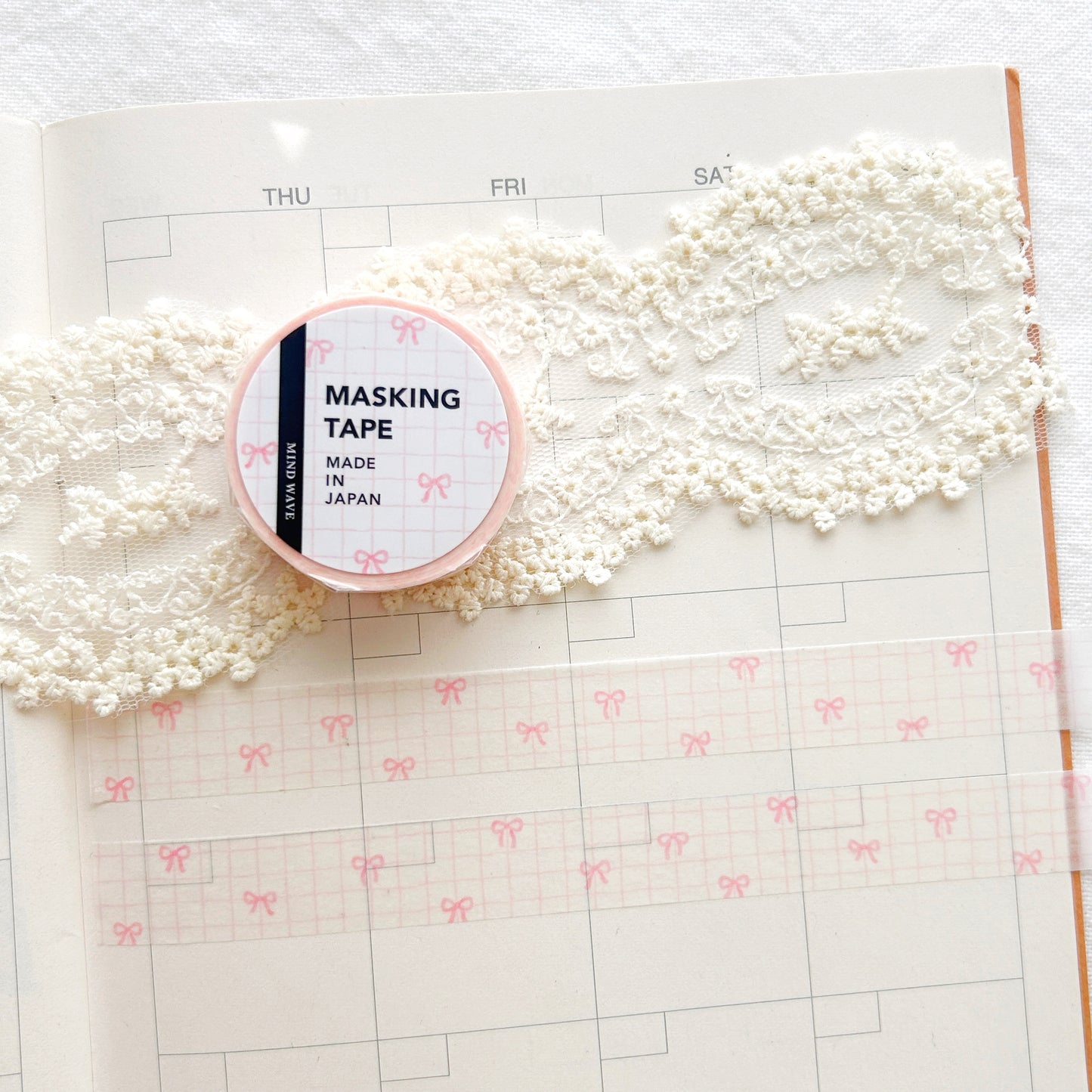 Washi tape roll with a pink and white check pattern and pink bows illustration on a planner
