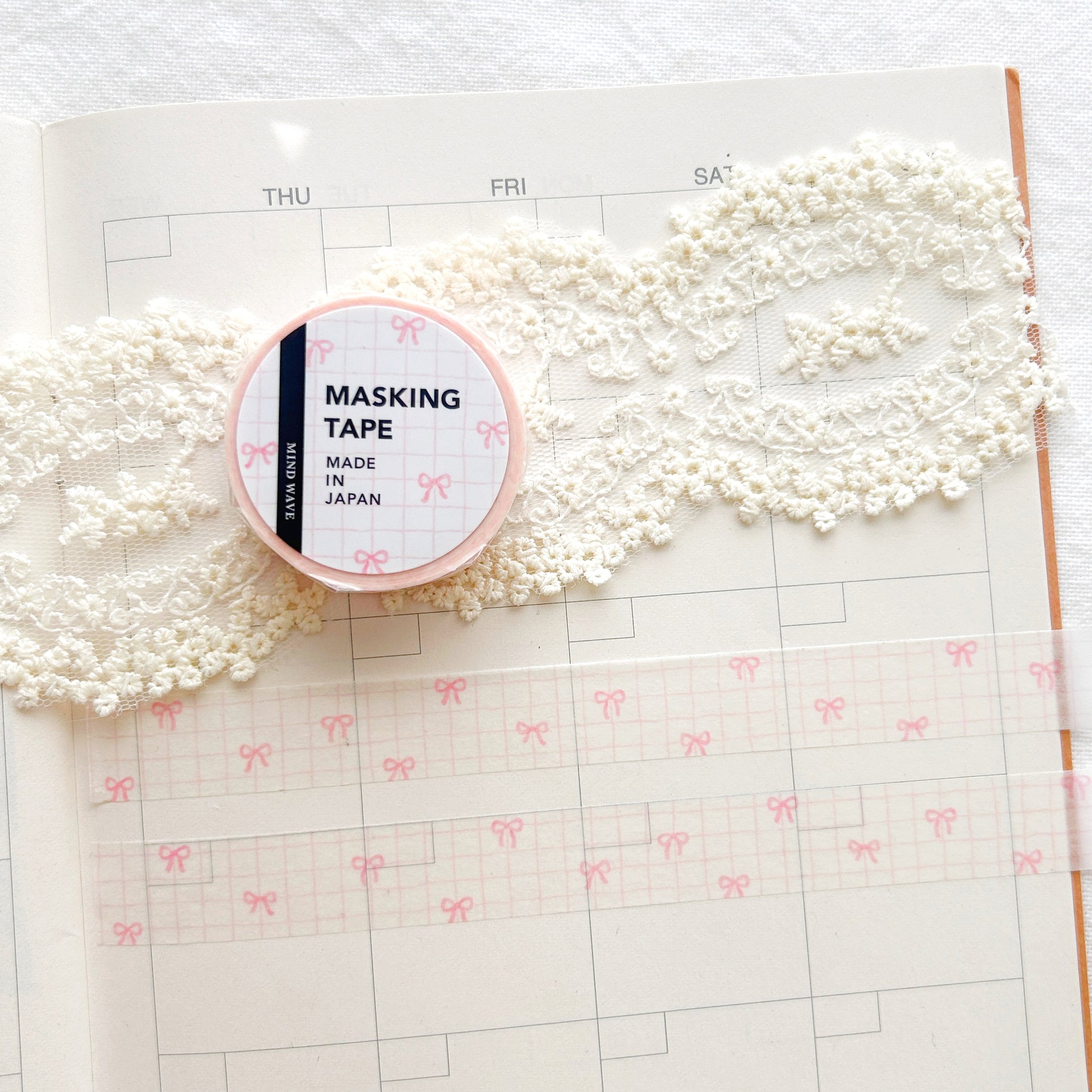 Washi tape roll with a pink and white check pattern and pink bows illustration on a planner