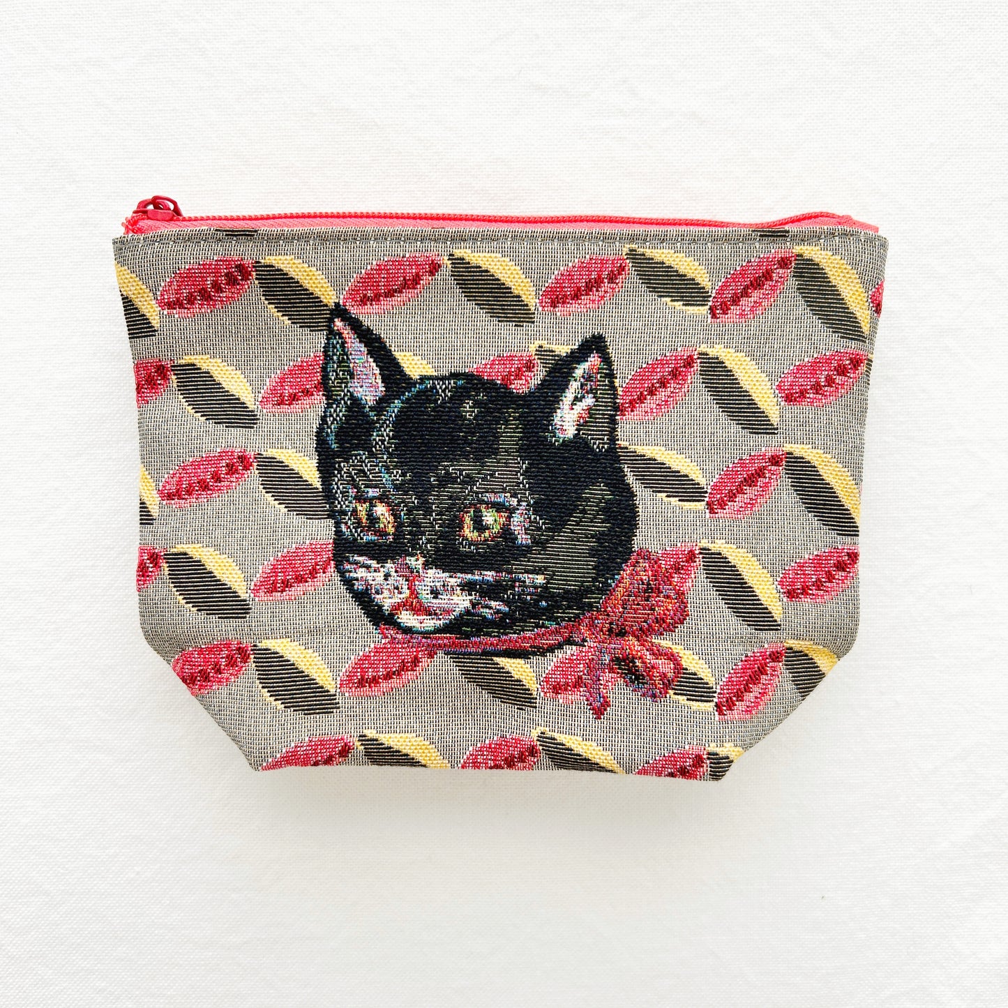 Small pouch with a black cat design on a floral patterned background
