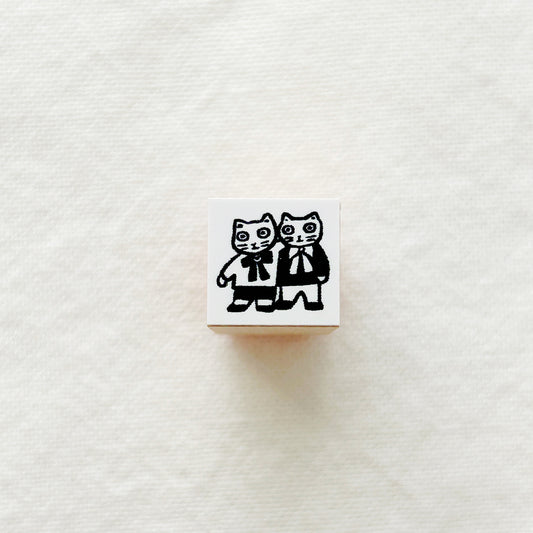 Small wooden rubber stamp with black and white illustrations of two cats.