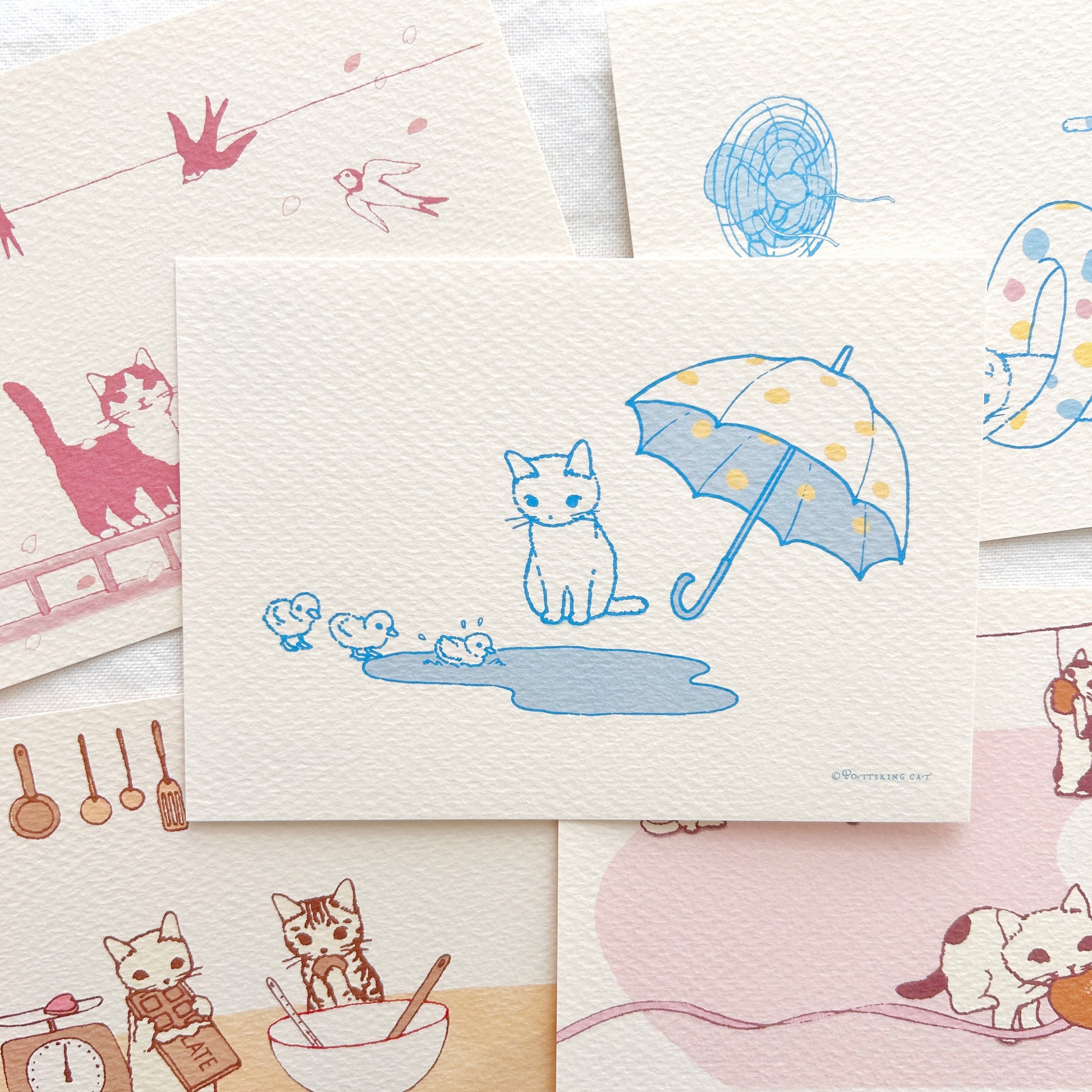 Collection of illustrated postcards featuring cats and various scenes on a white background.