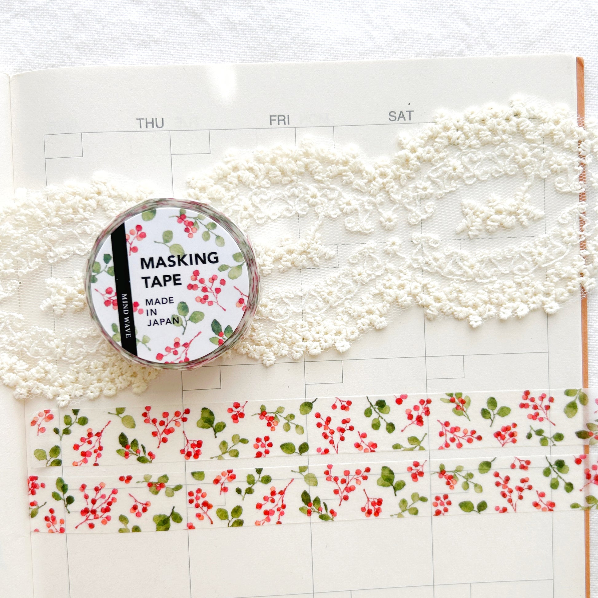 Washi tape with red and green floral design on a planner