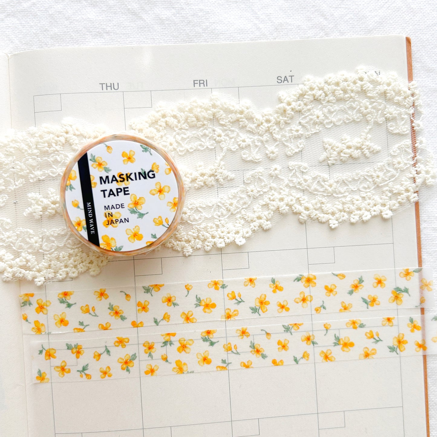 Washi tape with whimsical yellow floral design on a planner page