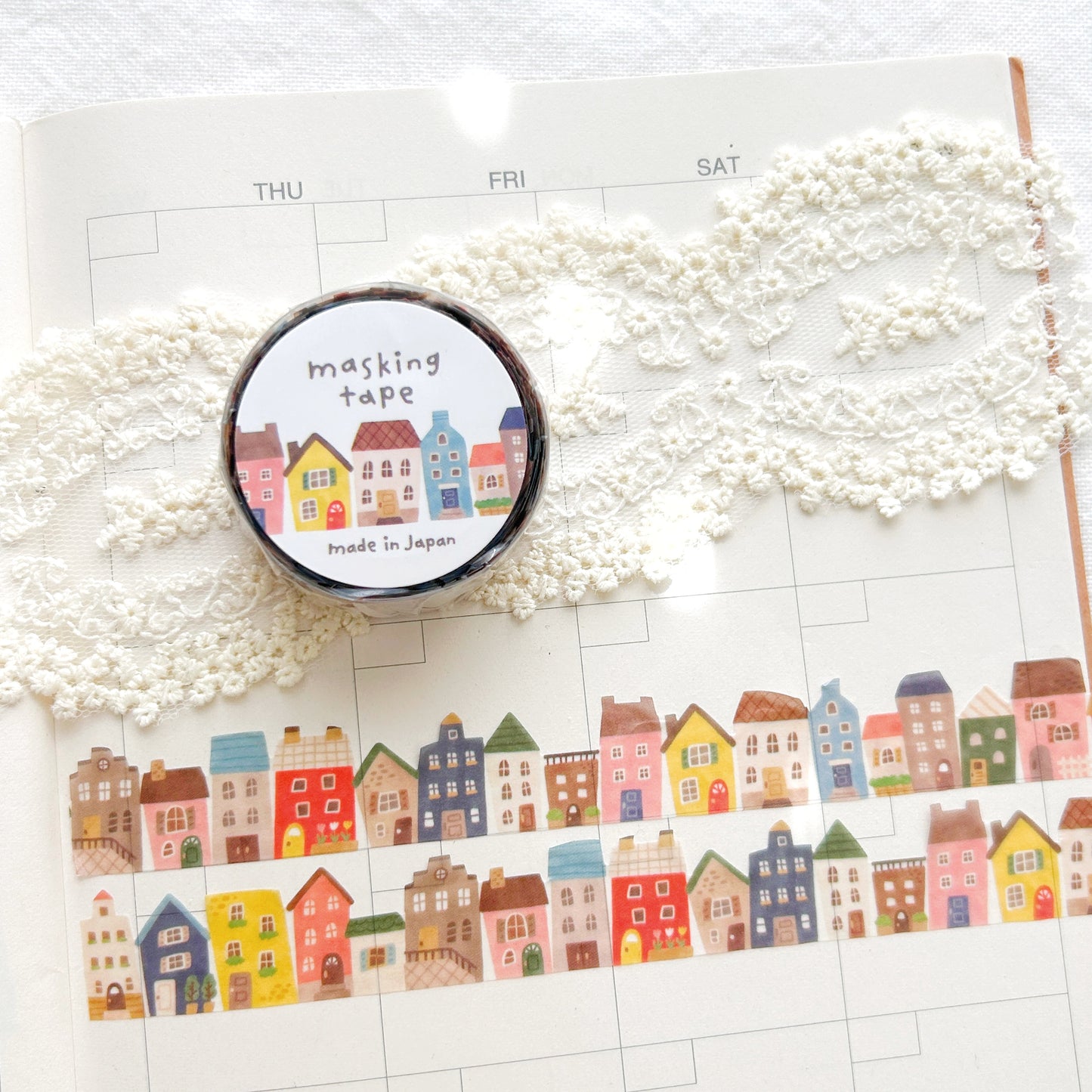 Roll of washi tape with colorful house designs on a planner
